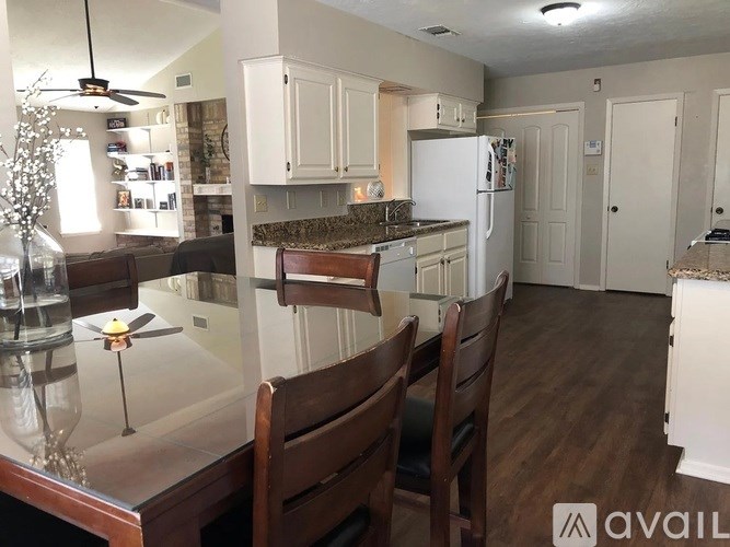 A kitchen with white cabinets and a marble countertop.