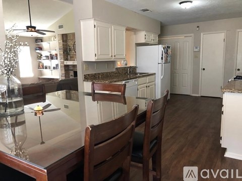 A kitchen with white cabinets and a marble countertop.