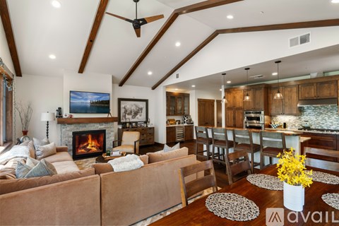 A living room with a fireplace and a television on the wall.