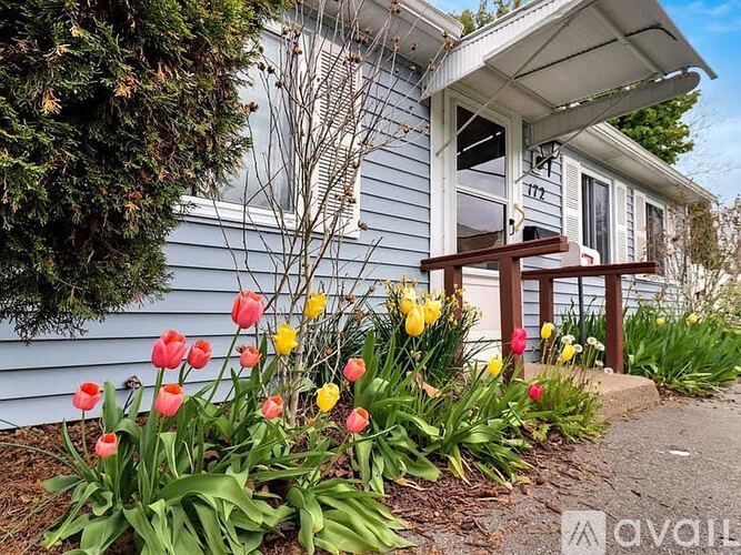 A house with a flower bed in front of it.