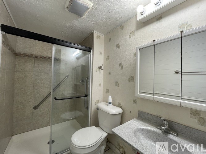 A bathroom with a toilet, sink, and shower.
