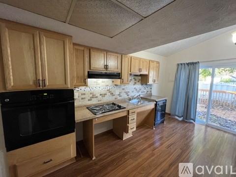 A kitchen with wooden cabinets and a black oven.