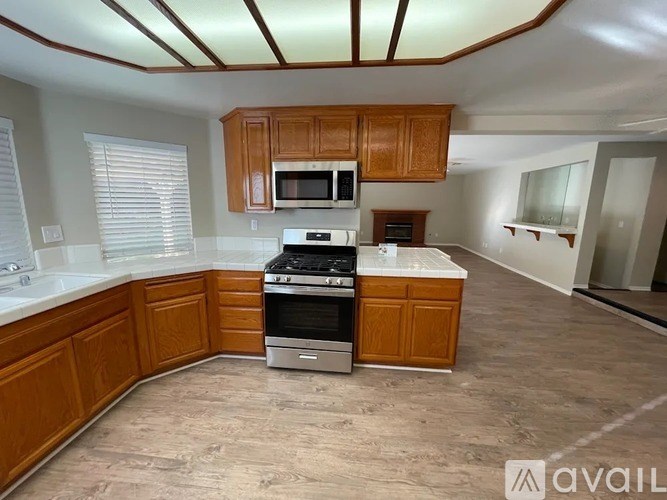 A kitchen with wooden cabinets and a stainless steel stove top oven.