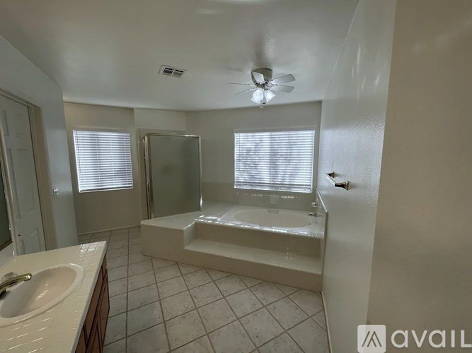 A bathroom with a white tub, sink, and mirror.