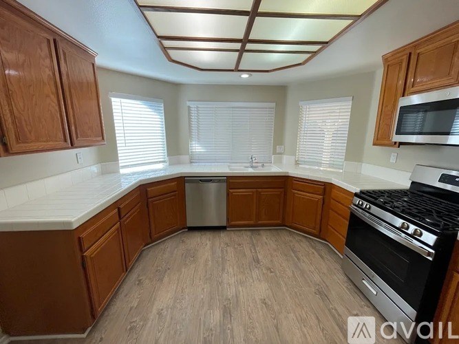 A kitchen with wooden cabinets and a stainless steel dishwasher.