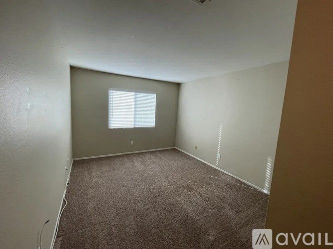 A room with a window and carpeted floor.