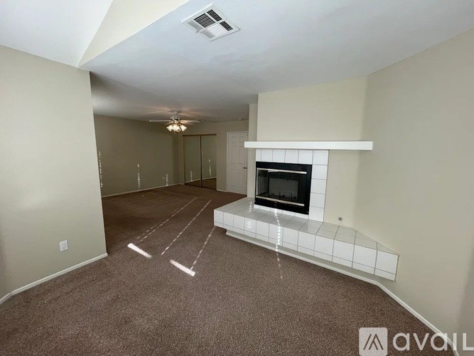 A living room with a fireplace and a carpeted floor.