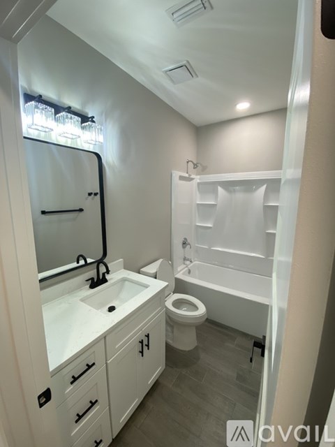A bathroom with a sink, toilet, and bathtub.