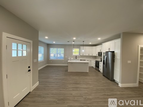 A spacious kitchen with a refrigerator, microwave, and oven.