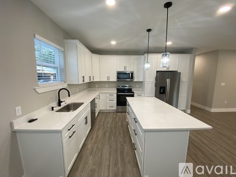 A modern kitchen with white cabinets and a large island.