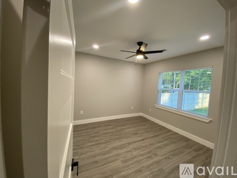A room with a ceiling fan and a window with blinds.