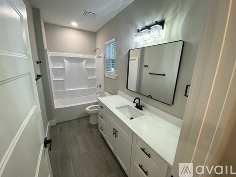 A bathroom with a white vanity and a walk-in shower.