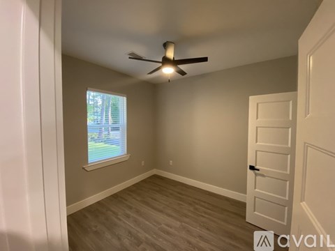 A room with a ceiling fan and a window.