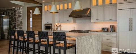 A kitchen with white cabinets and a marble countertop.