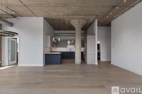 A spacious room with a kitchen area and a large island in the middle.