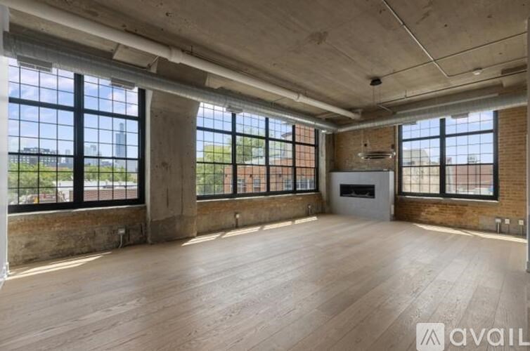 A large empty room with wooden floors and large windows.