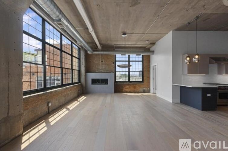 A spacious room with large windows and exposed ceiling beams.