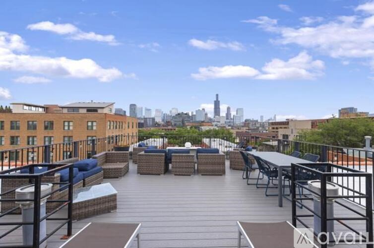A rooftop patio with a table and chairs overlooking a city skyline.