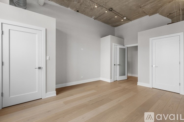 A room with white doors and wooden flooring.
