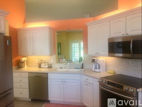 A kitchen with white cabinets and a stainless steel dishwasher.