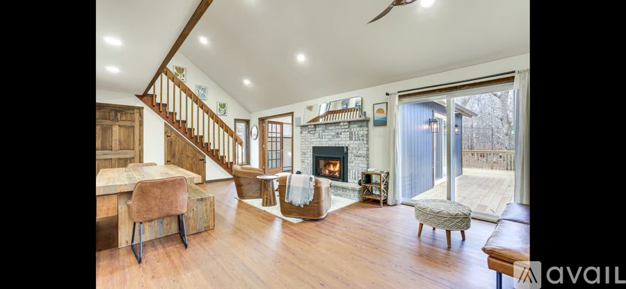 A spacious living room with a fireplace and a staircase.