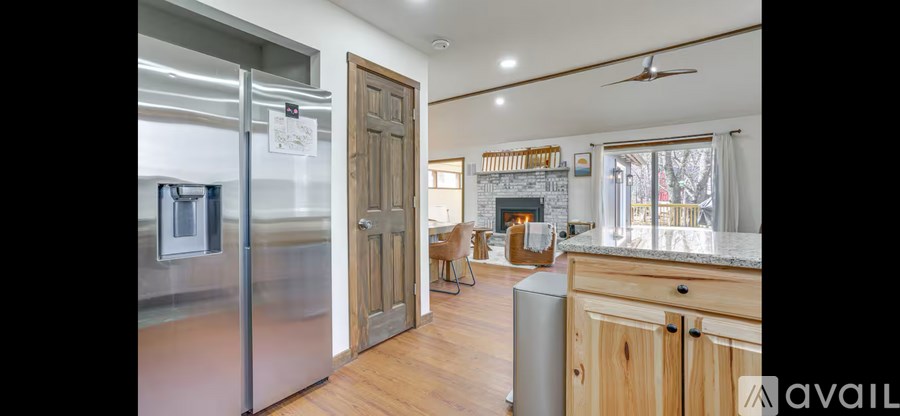 A kitchen with a refrigerator, a fireplace, and a dining area.