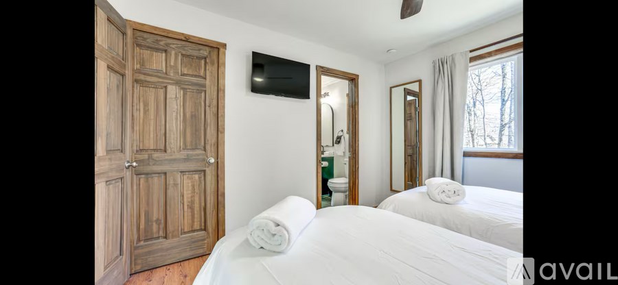 A bedroom with two beds and a wooden door.