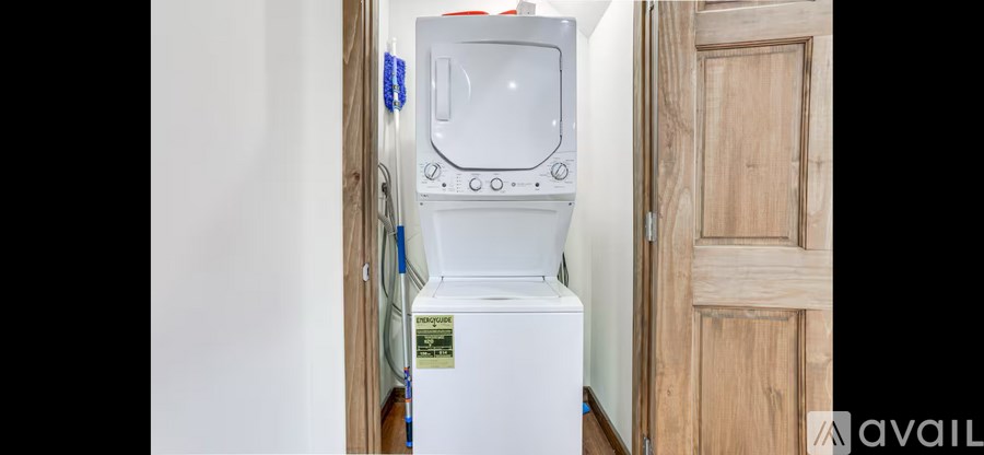 A white washing machine is in a small room.