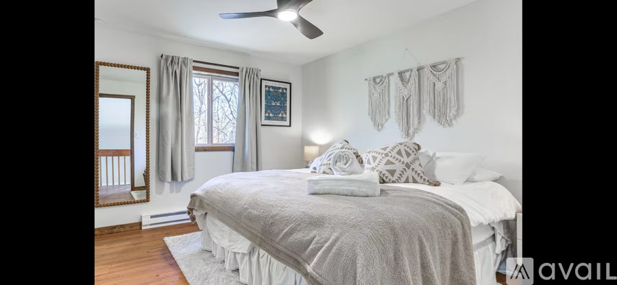 A bedroom with a large bed and a ceiling fan.
