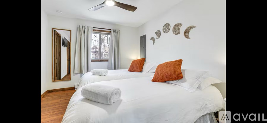 A bedroom with two beds and a mirror on the wall.