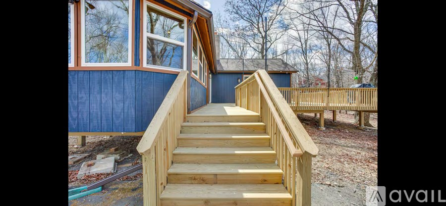 A wooden staircase leads to a blue building.