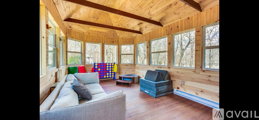 A living room with a grey couch and a wooden ceiling.