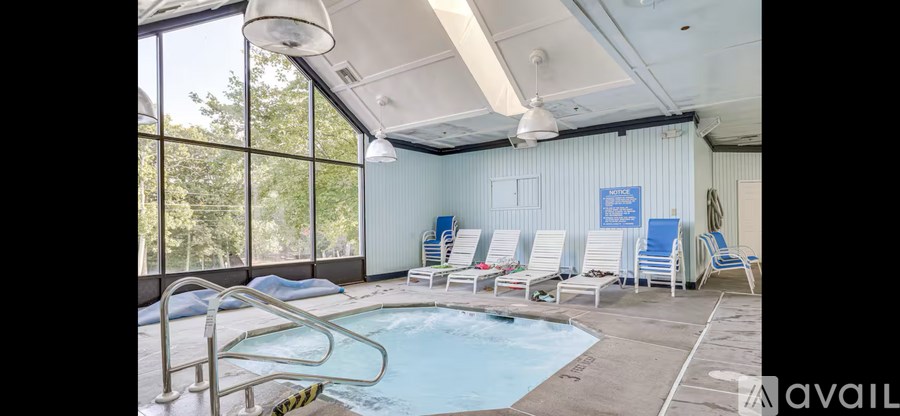 A large indoor swimming pool with lounge chairs and a sign that says "available.".