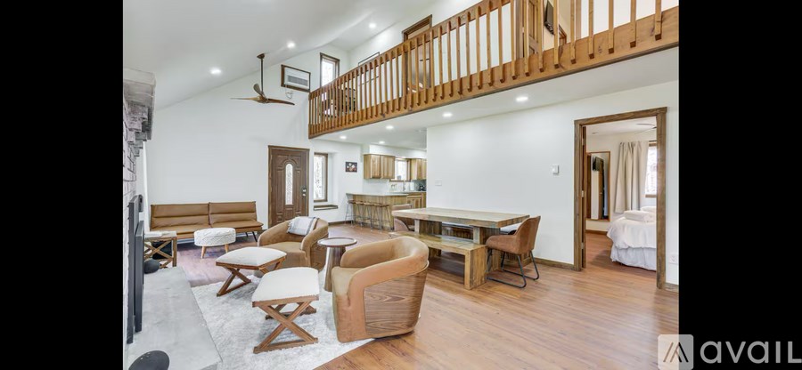 A living room with a couch, chairs, and a table.