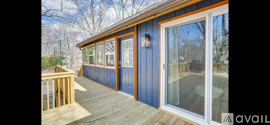 A deck with a blue wall and a wooden floor.