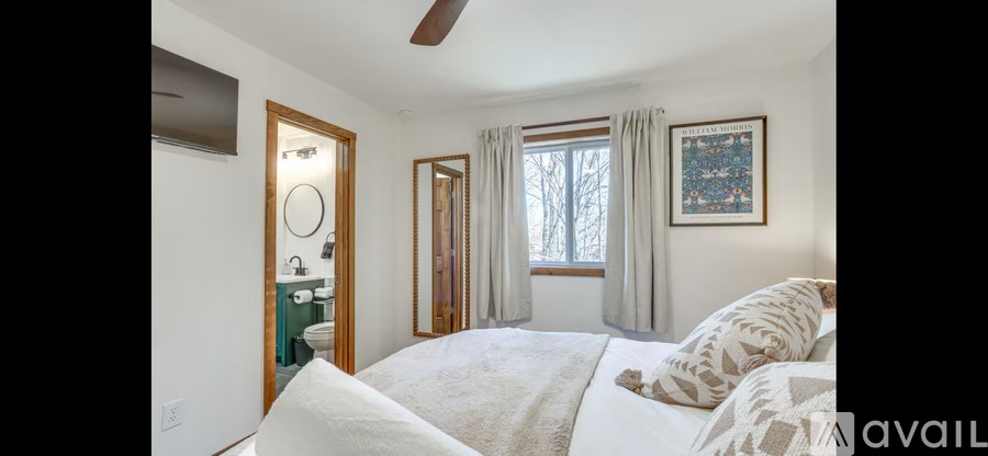 A bedroom with a bed, a dresser, and a window.