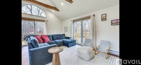 A living room with a blue couch and a wooden table.