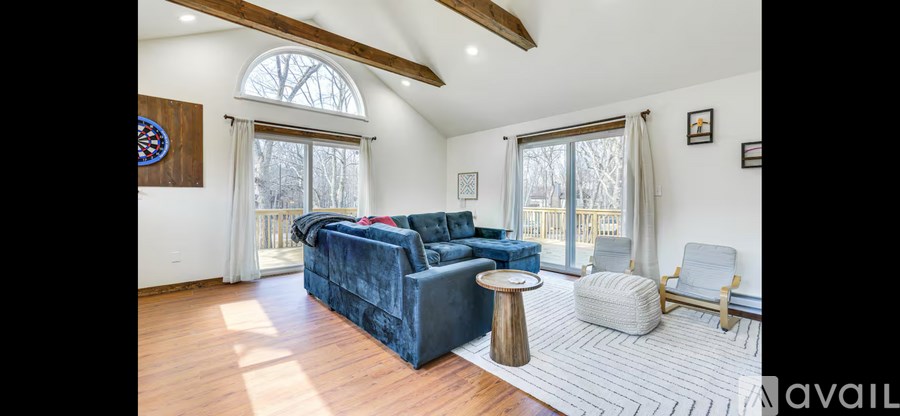 A living room with a blue couch and a wooden floor.