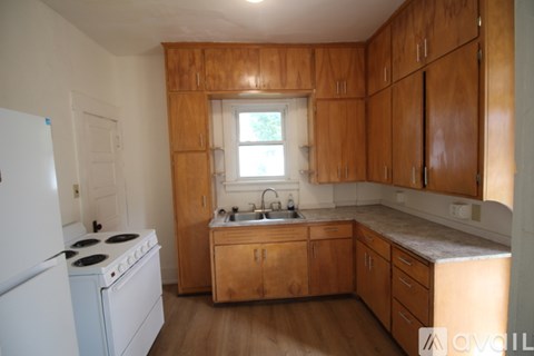 A kitchen with wooden cabinets and a white fridge.