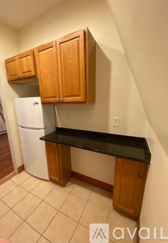 A kitchen with wooden cabinets and a black countertop.