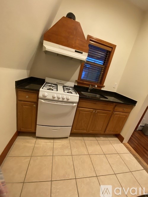 A kitchen with a stove, oven, and a window.