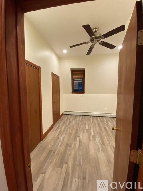 A room with wooden floors and a ceiling fan.