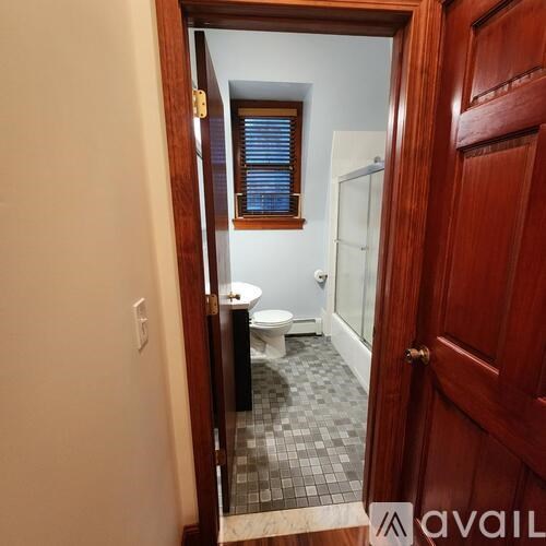 A bathroom with a toilet, sink, and mirror.