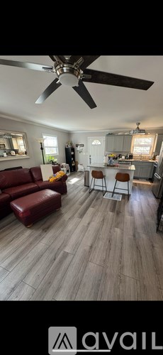 A living room with a red couch and a ceiling fan.