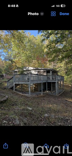 A dilapidated wooden structure sits in a field.