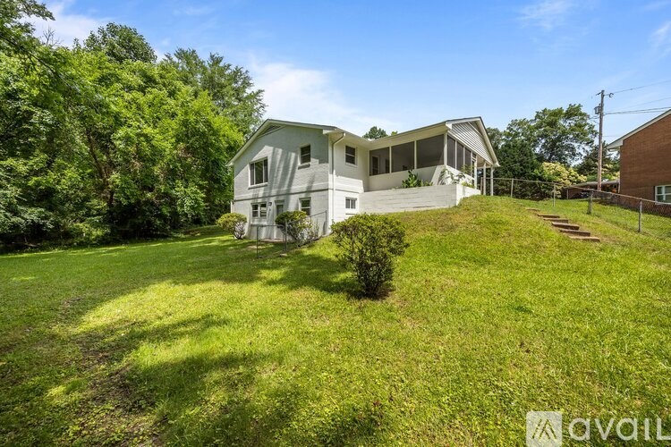 A house with a lawn and trees in the background.