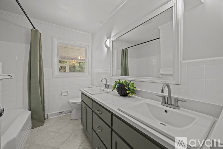 A bathroom with a white sink and a large mirror.