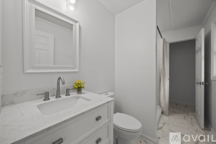 A bathroom with a sink, toilet, and a mirror.