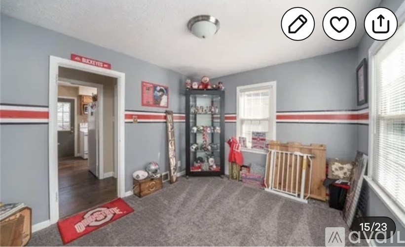 A room with a grey wall and a red mat on the floor.