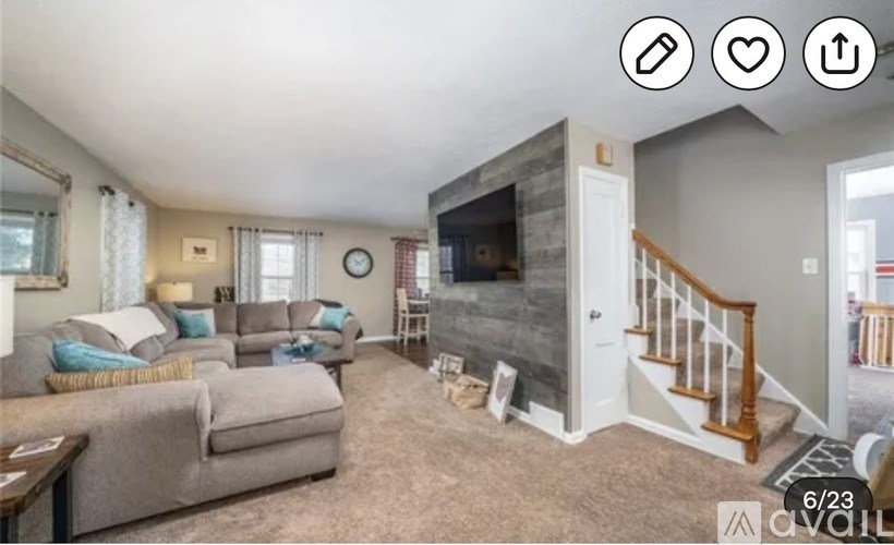 A living room with a grey couch and a fireplace.